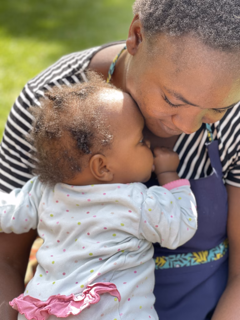 A woman holding a baby close at His Cherished Ones